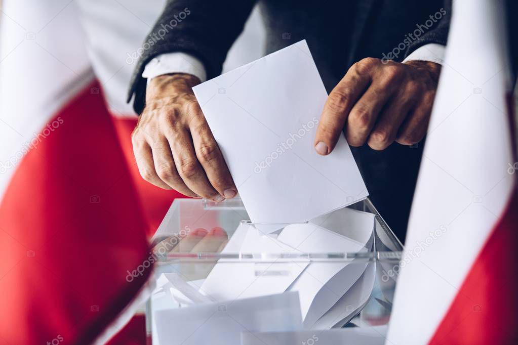 Man putting his vote do ballot box. Political elections