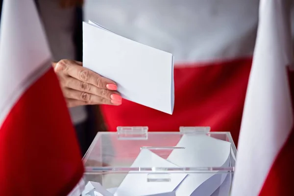Жінка ставить її голосування в Урна для голосування. Політичні вибори в Польщі — стокове фото