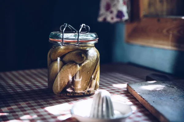 Inlagda gurkor i glasburk på bordet — Stockfoto