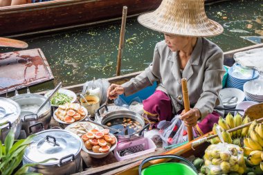 Damnoen Saduak, Tayland - 8 Ekim 2018: kayan Pazar yiyecek hazırlama kadın satıcı. Piyasada bir çok poular turistik yer.