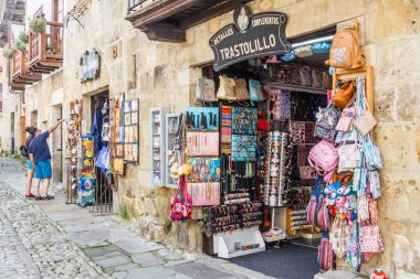 Santillana, İspanya - 8 Temmuz 2018: Hatıra Eşyası bir dükkanının bakarak turistler. Çok sayıda turistin kentini ziyaret.