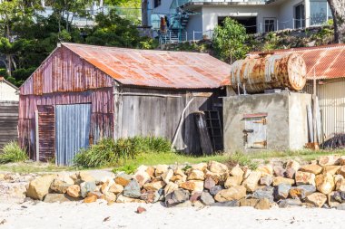Oluklu kulübe ile petrol depolama davul, deniz kenarında Pambula river Haliç, New South Wales, Avustralya