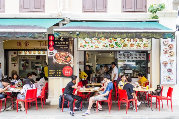 Människor som äter på gatan utanför en restaurang — Stockfoto