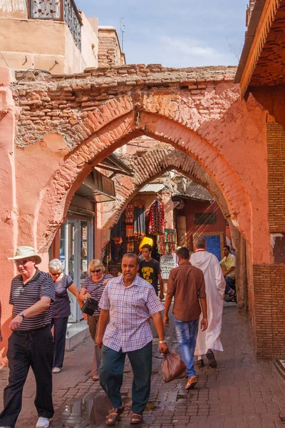 People walking through an archway — Stock Photo, Image