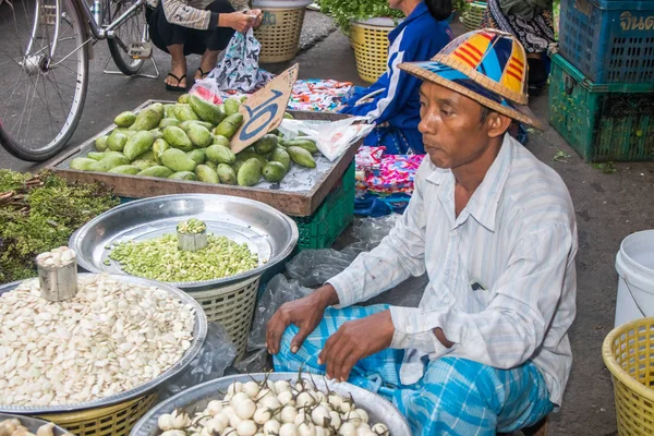 Homem de chapéu vendendo legumes — Fotografia de Stock