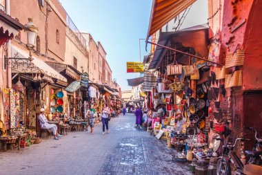 Çarşıda bir sokakta yürüyen turistler