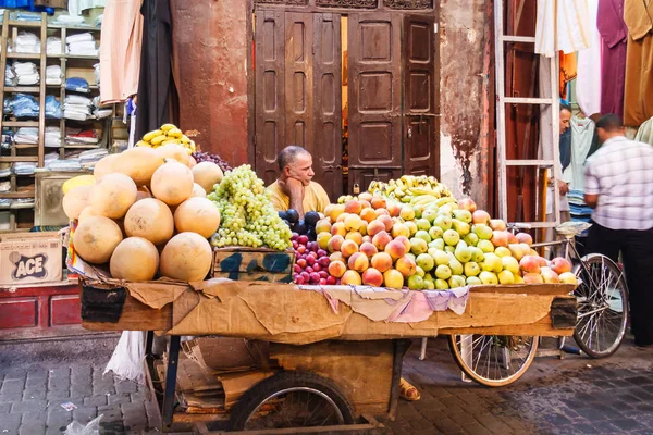 Hombre vendiendo fruta de un carrito — Foto de Stock