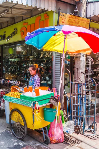 Renkli bir şemsiye altında portakal suyu satıcısı — Stok fotoğraf