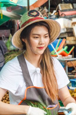 Khlong Toei pazarındaki genç kız satıcı.