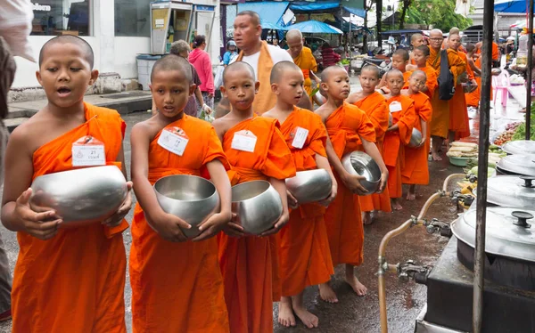 Monjes novatos recogiendo limosnas en el mercado en la antigua ciudad de Phuket, T —  Fotos de Stock