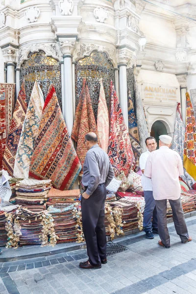 Men talking outside a turkish carpet shop — Stock Photo, Image