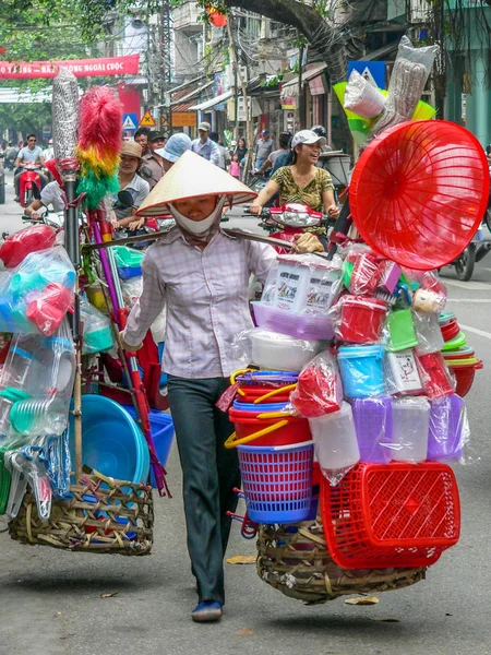 Woman vendor carrying and selling household goods — Stock Photo, Image