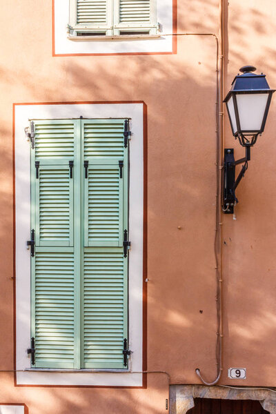 Lamp and window with shutters in Villefranche sur Mer, France