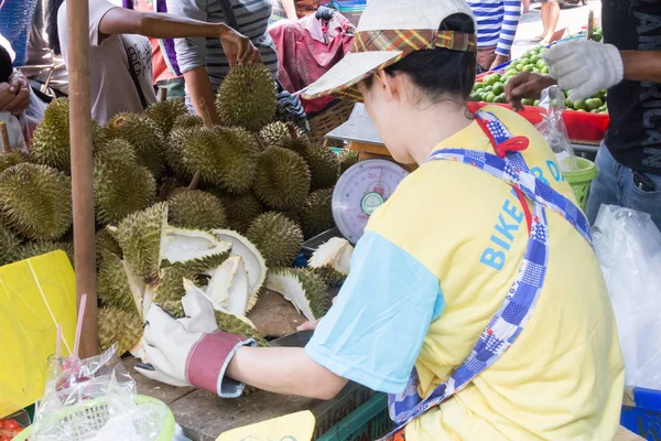 Žena rozřezává Durianské ovoce na Khong Toei mokrý trh v Bangko. — Stock fotografie