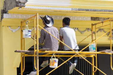 Erkekler Bangkok, Tayland bir ev boyama iskele oturdu