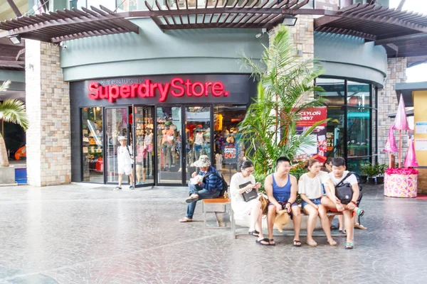 Kínai turisták kívül ülve Superdry áruház. — Stock Fotó