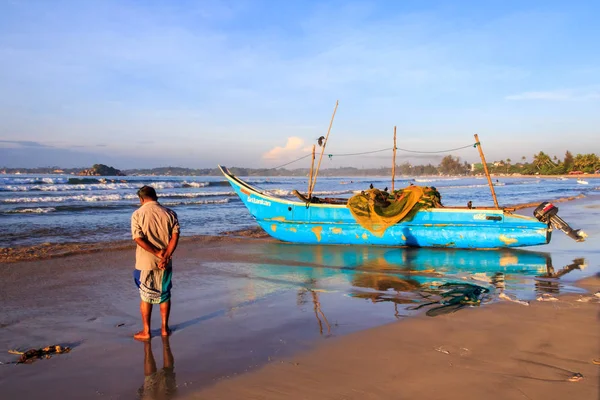 Man stood by a traditional fishing boat — Stock Photo, Image