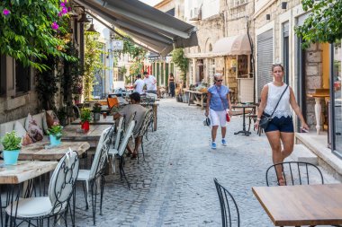 Dar bir sokakta yürüyen turistler
