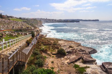İnsanlar kıyı yolunda yürüyor.