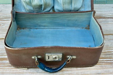 Eski bavul eski ahşap bir masada yatıyor, açık.