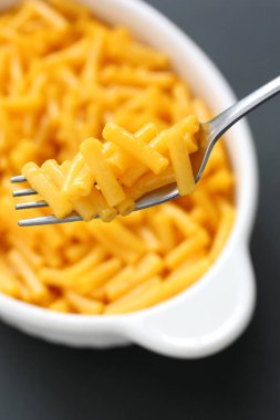 siyah arka plan üzerinde izole bir çatal üzerinde makarna ve peynir