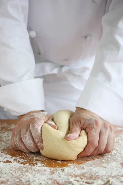 baker making bread , man hands , kneading a dough , cooking coat