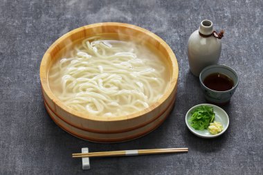 Kamaage udon bir çeşit Japon Udon düğümleri, sade sıcak udon eriştesi ahşap kovada ve sosta.