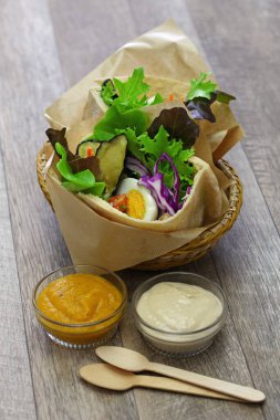 Kızarmış patlıcanlı, haşlanmış yumurta, İsrail salatası, amba ve tahini soslu İsrail Pide sandviçi.
