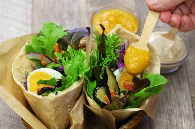 Kızarmış patlıcanlı, haşlanmış yumurta, İsrail salatası, amba ve tahini soslu İsrail Pide sandviçi.