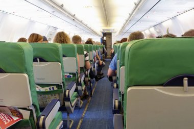 Amsterdam, Hollanda - 25 Eylül 2018: Turist sınıfı uçak hazır için onların koltuklarda oturan yolcuların çıkar.                               