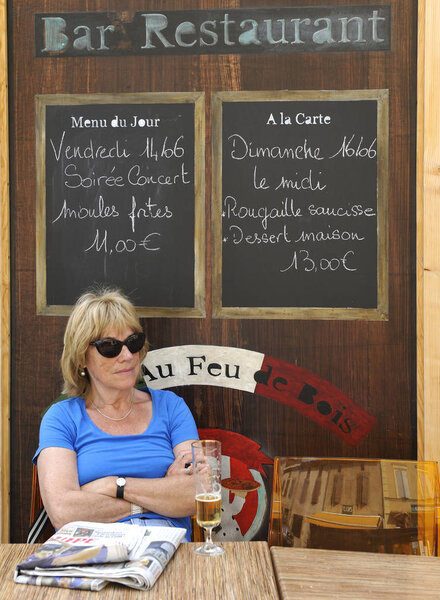 Tourist drinking a beer at a French cafe terrace