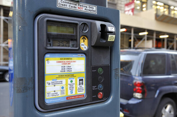 New York, USA-November 14,2012: Commercial Parking Only Parking meter with at background a car.