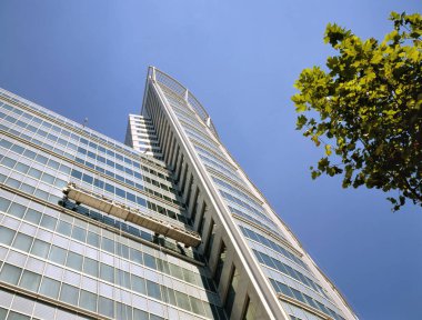 Büyük bir ofisin camlarını temizleyen pencere temizleyicisi.