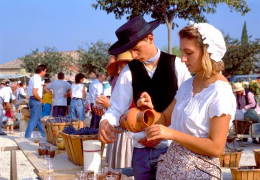 Coustelet, Fransa-Eylül 29-2019: Geleneksel kostüm içinde şarap servisi yapan kız ve oğlanlarla yapılan şarap toplama partisinin sonu