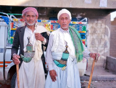Baraqish, Yemen-19 Ekim 1999: Geleneksel kıyafetler giyen ve janbiyalarını sergileyen iki Yemen erkeğinin portresi (geleneksel hançerler)) 
