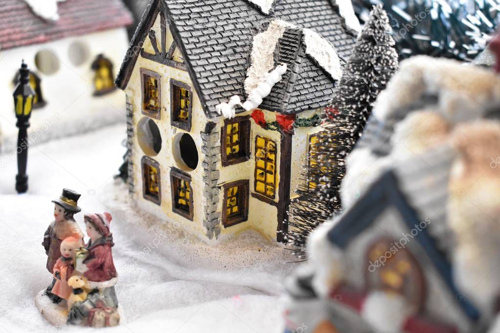 Christmas Decorating, small houses and people in the snowy street