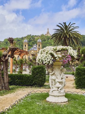 Alderdi-Eder gardens and City hall building of San Sebastian in background at sunny day. Donostia, Basque Country, Guipuzcoa. clipart