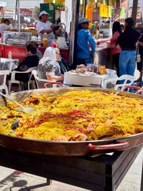 Madrid, İspanya - 15 Mayıs 2018. Gastronomik bir ahır Pradera de San Isidro Madrid park San Isidro Labrador şenlik, İspanyol Paella yemek Chulapos kılığında vatandaşlar.