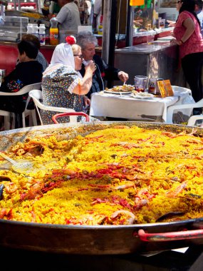 Madrid, İspanya - 15 Mayıs 2018. Gastronomik bir ahır Pradera de San Isidro Madrid park San Isidro Labrador şenlik, İspanyol Paella yemek Chulapos kılığında vatandaşlar.