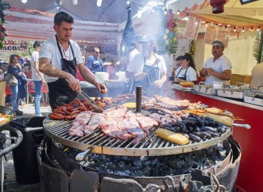 Madrid, İspanya - 15 Mayıs 2018. İspanyol yemek pişirme sosis, domuz yedek kaburga ve diğerleri üzerinde bir ahır bir sokak gıda fuarı kömür bir barbekü et.