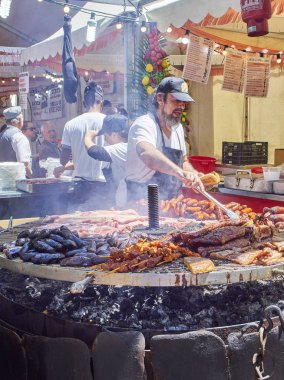 Madrid, İspanya - 15 Mayıs 2018. İspanyol yemek pişirme sosis, domuz yedek kaburga ve diğerleri üzerinde bir ahır bir sokak gıda fuarı kömür bir barbekü et.