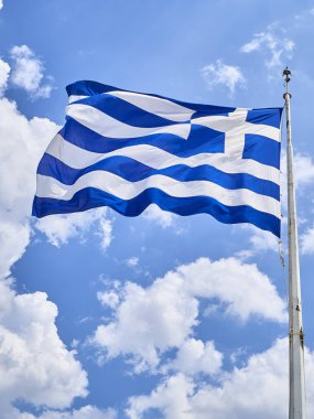 Yunanistan bulutlu bir gökyüzü sallayarak resmi bayrak.
