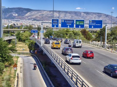 Athens, Greece - June 29, 2018. Traffic on Piraeus to Athens highway at Neo Faliro, with Athens city in background. clipart