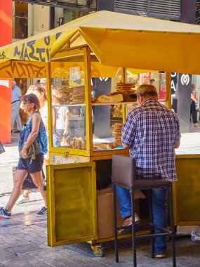Atina, Yunanistan - 30 Haziran 2018. Bir satıcı onun Koulouri'nin ahır bir sokakta Atina önünde. Attica bölgesi, Yunanistan.
