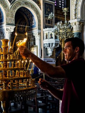 Atina, Yunanistan - 30 Haziran 2018. Ayrıca Mitropoli veya metropol olarak bilinen duyuru, Büyükşehir katedral mum söndürme bir çalışanı. Atina, Attica bölgesi, Yunanistan.