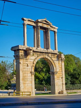 Atina, Yunanistan - 30 Haziran 2018. Kız Hadrian Arch veya Hadrian'ın kapısı, eski anıtsal zafer kemerli kapı Leoforos Vasilisis Amalias, ana caddenin Atina, Korint sütunları ile yakın yürümek. Attica, Yunanistan.