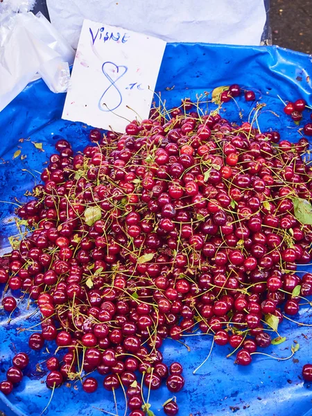Cherries for sale in stall of a Turkish market with a cartel in Turkish showing the price.