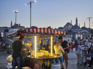 Istanbul, Türkiye - 7 Temmuz 2018. Gün batımında arka planda Rüstem Paşa Camii ve Süleymaniye Camii camiler ile Eminönü, bir eski Istanbul 'un ilçesinde, Türkiye, bir sokakta Mısır koçanı durak.