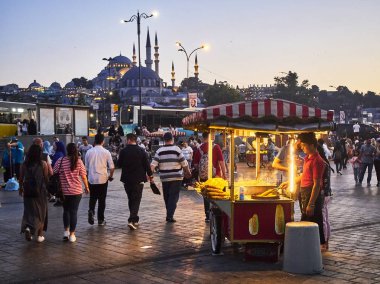 Istanbul, Türkiye - 7 Temmuz 2018. Gün batımında arka planda Rüstem Paşa Camii ve Süleymaniye Camii camiler ile Eminönü, bir eski Istanbul 'un ilçesinde, Türkiye, bir sokakta Mısır koçanı durak.
