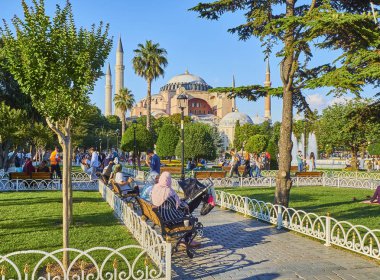 Istanbul, Türkiye - 8 Temmuz 2018. Vatandaşlar Ayasofya Sophia cami içinde belgili tanımlık geçmiş ile Sultanahmet parkta güneşli bir zevk. Istanbul, Türkiye.